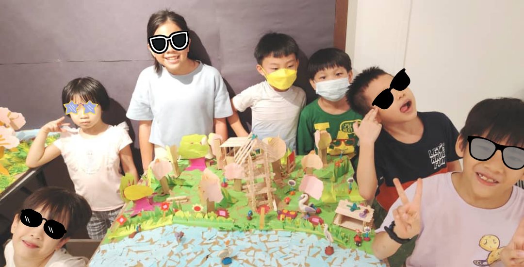 Bilden students gathered behind the model landscape they built together
